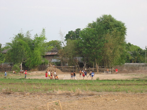 Village kids playing soccer on a dirt field in Mae Pa